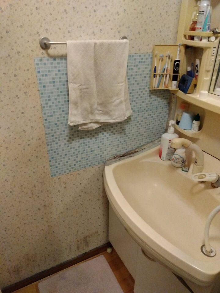洗面所の汚れた壁紙