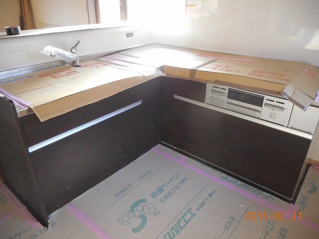 広々としたL字キッチンを組み立てていきます。吊り戸棚や扉も取り付けます。
